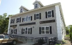 A 2-story gray building with white trim