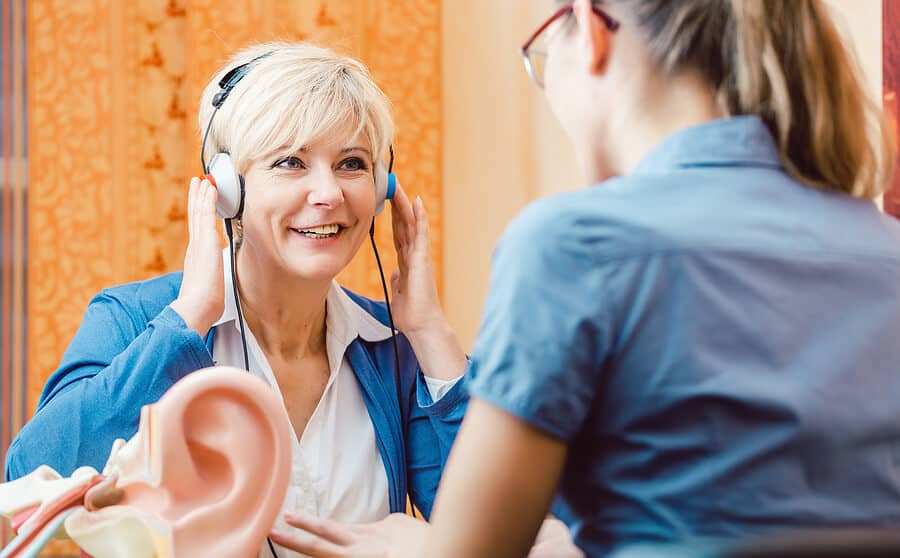 Deaf woman takes a hearing test with audiologist